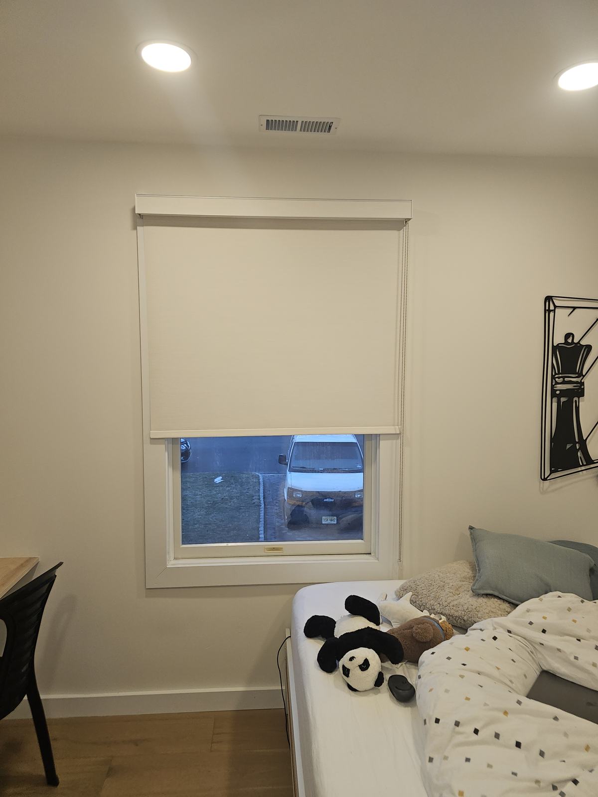 The same child's bedroom window with the blackout roller shade raised into its cassette
