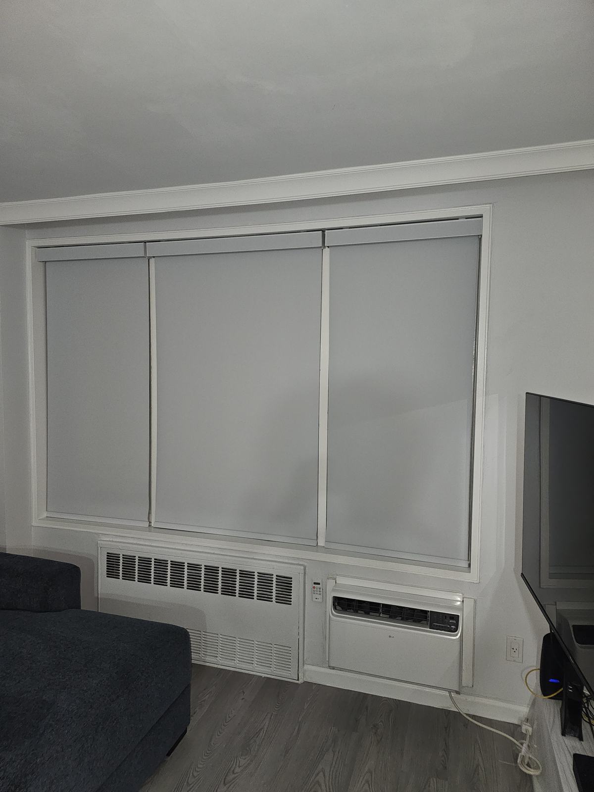 One wide roller shade covering a living room sliding window in a completed ModuShade installation