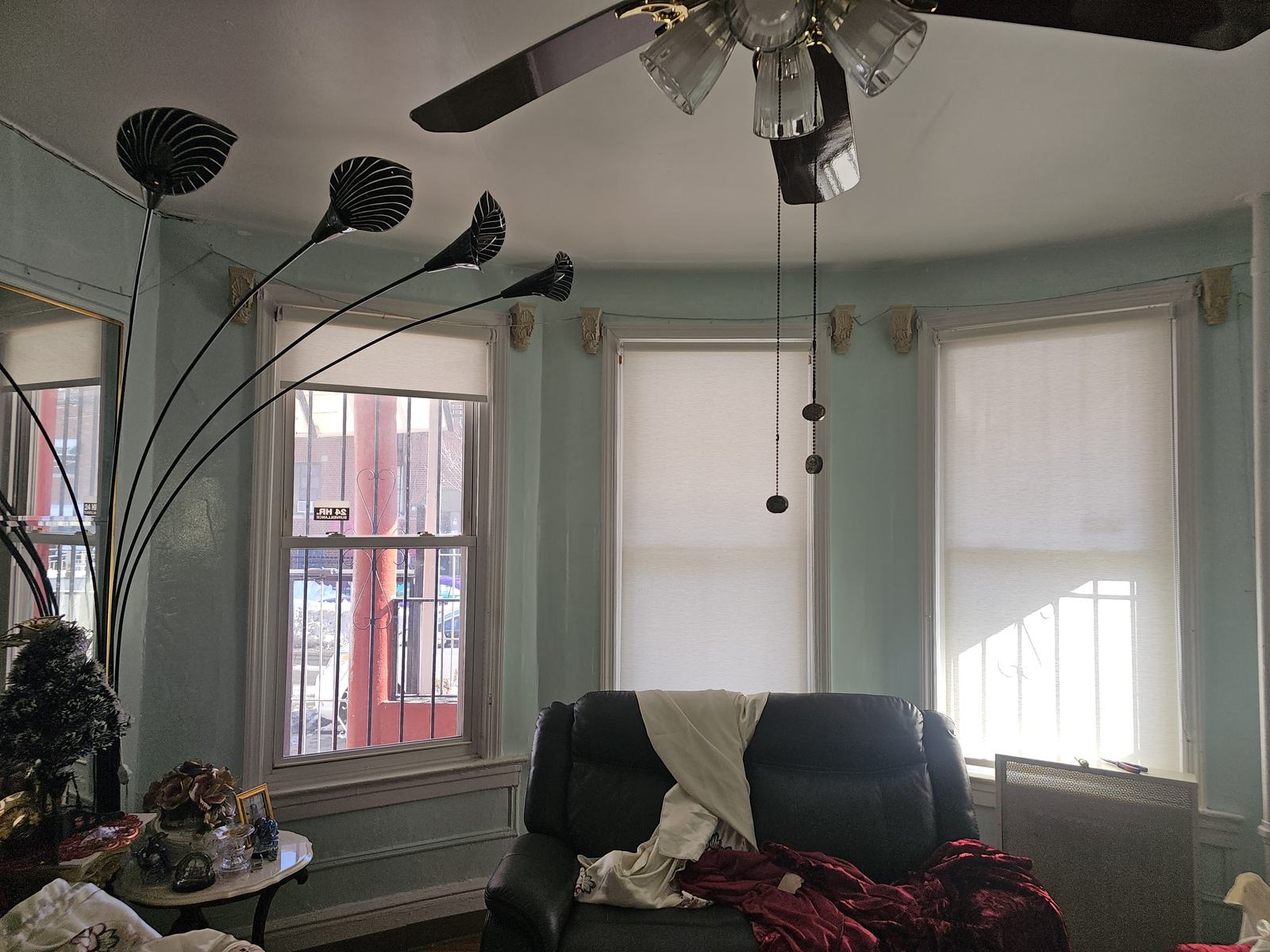 Sheer shades fitted as three panels across the bay window of an apartment living room